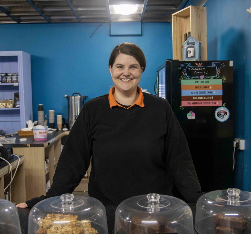 Cove Group team member standing behind a counter in an indoor room.